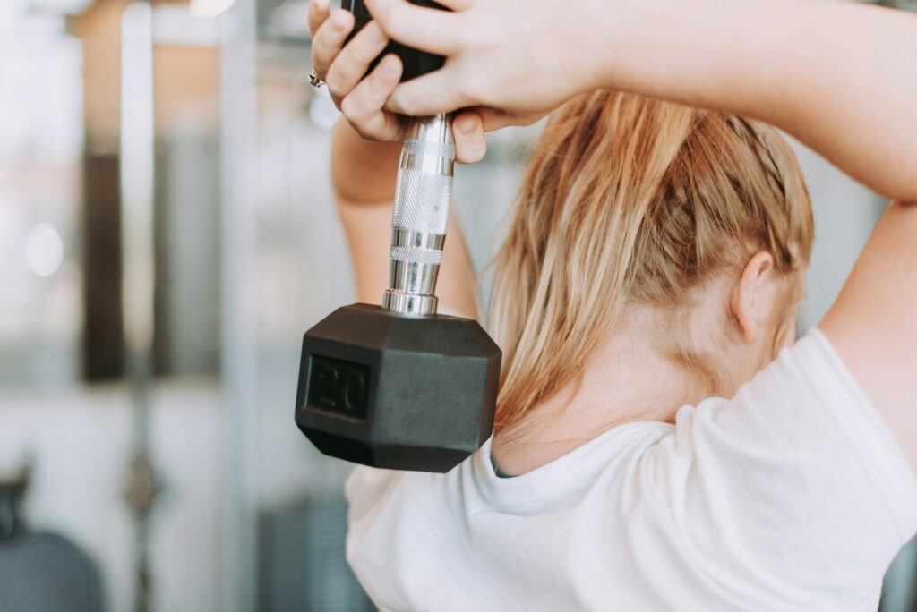 Woman performing an overhead dumbbell triceps extension
